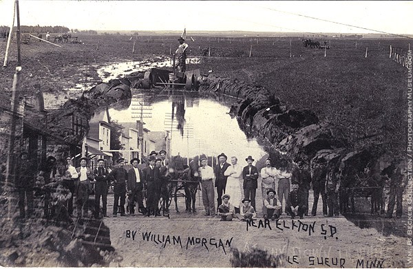 William Morgan, “Town and Country,” c. 1910 — a double-exposure photo postcard blending a rural scene with a crowd of townspeople